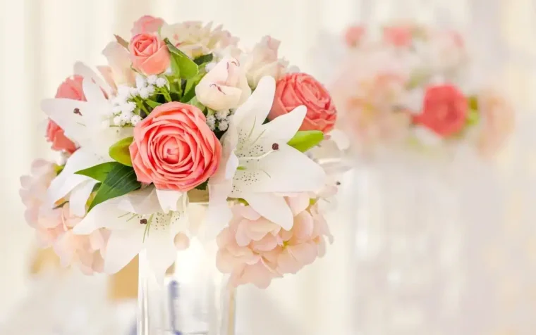 Pink roses and white lilies in a clear glass vase, showcasing PlantGrow's Natural Rose Fertiliser product.