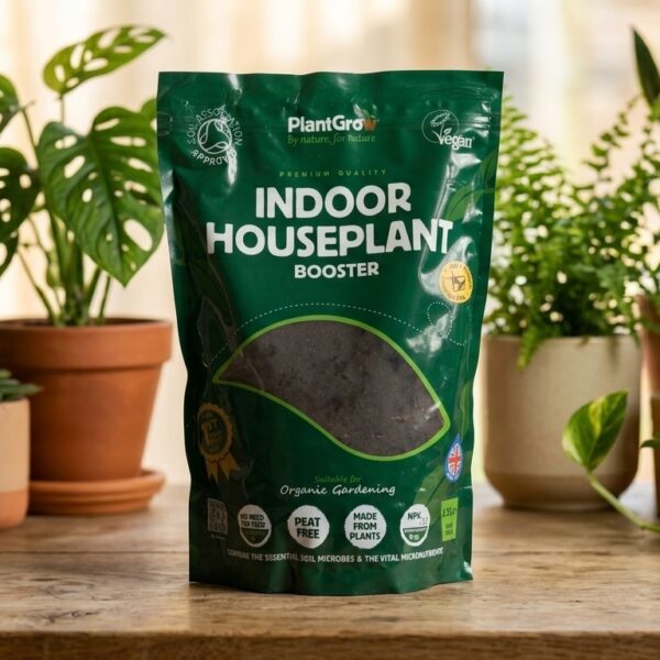 PlantGrow Indoor Houseplant Booster 2.5 litre bag displayed among potted houseplants on wooden surface.