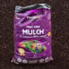 PlantGrow peat-free mulch bag on soil, purple packaging labelled soil conditioning natural fertiliser.