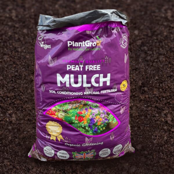 PlantGrow peat-free mulch bag on soil, purple packaging labelled soil conditioning natural fertiliser.
