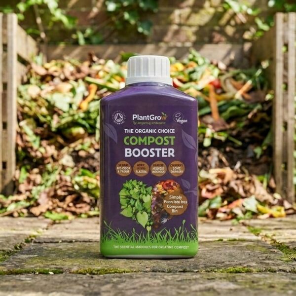 PlantGrow Natural Compost Booster 500ml bottle displayed on paving in a garden setting with compost bin behind.