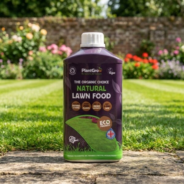 PlantGrow Natural Lawn Food Liquid bottle positioned on garden pathway with flowering borders and lawn visible behind.