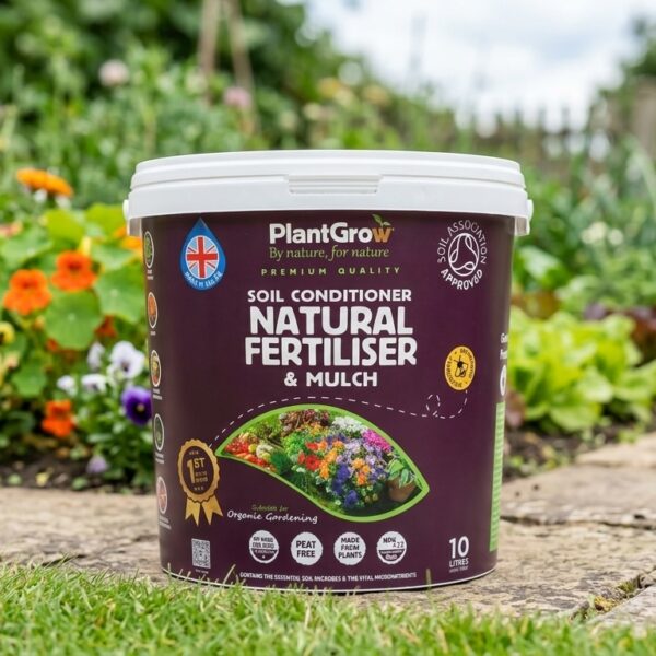 PlantGrow Natural Soil Conditioner 10 litre tub, a plant-based organic soil conditioner and mulch, displayed in a garden setting with flowering plants.